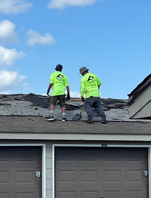 Woman in straw hat smiles, holding wine glass near a lake.