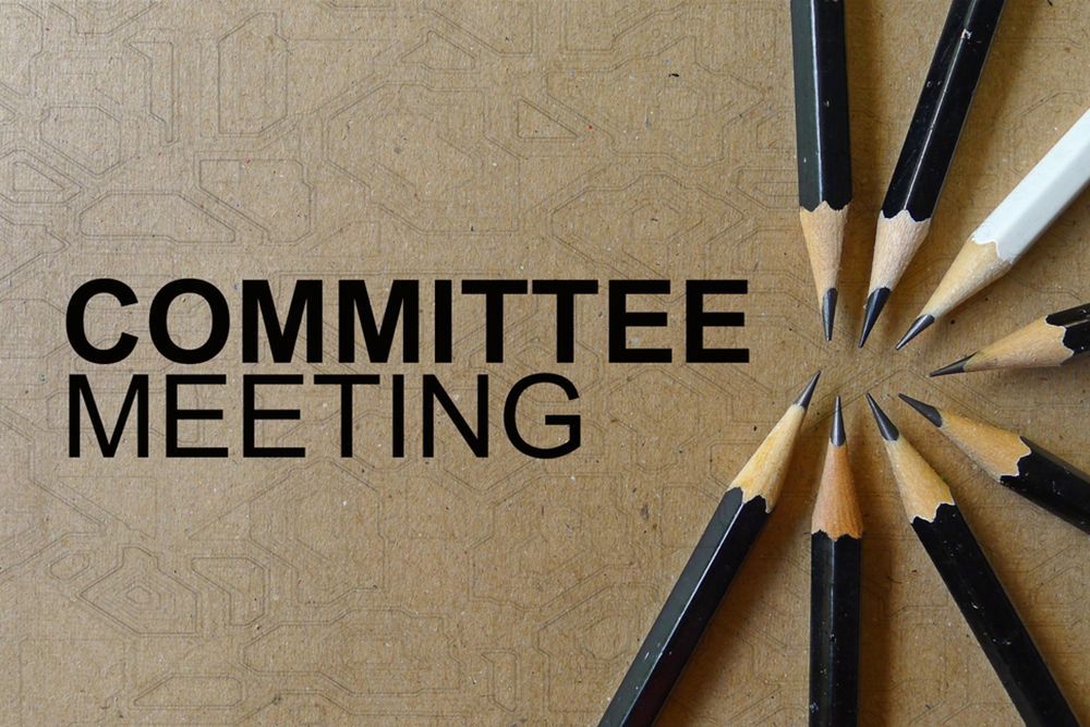 Committee Meeting text on brown background next to circle of pencils
