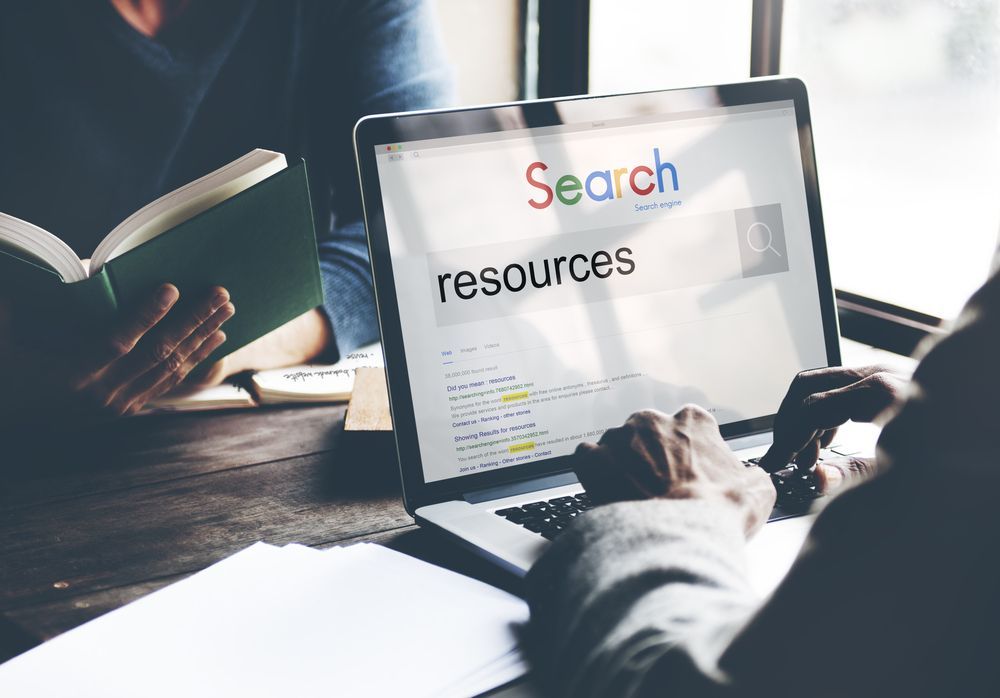 People using a laptop to search resources on screen