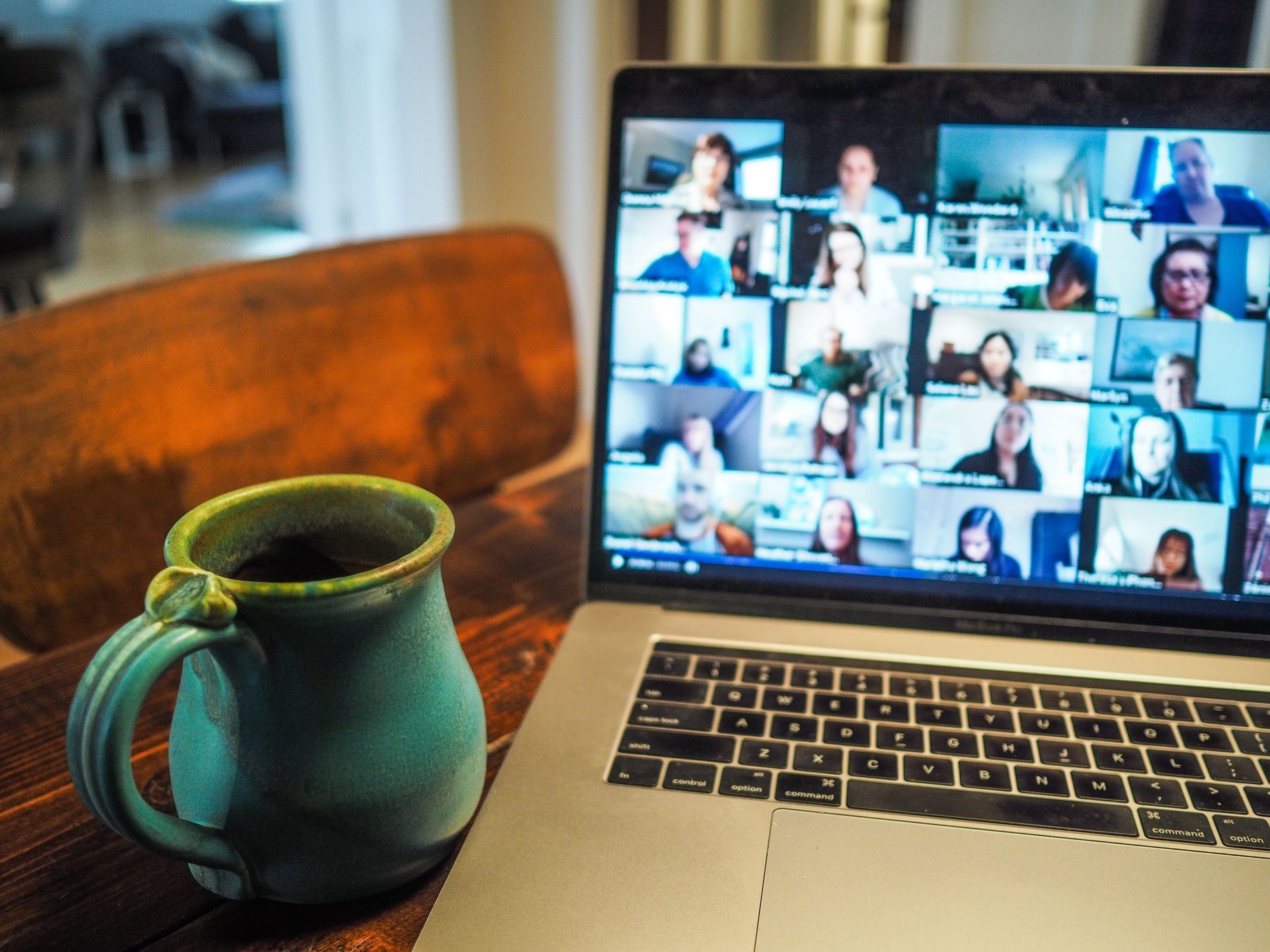 Coffee mug next to laptop with meeting displayed