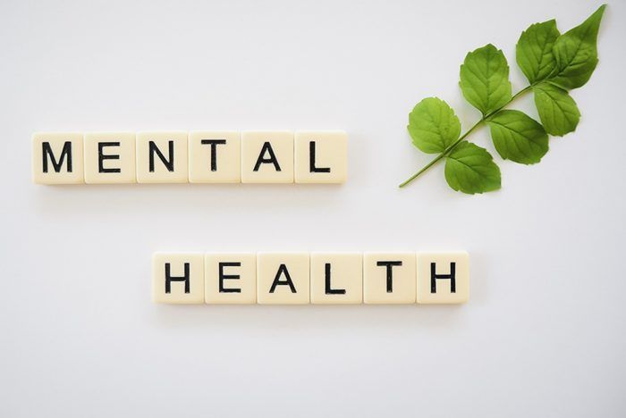 “MENTAL HEALTH” spelled in letter blocks with green leaves on a white background