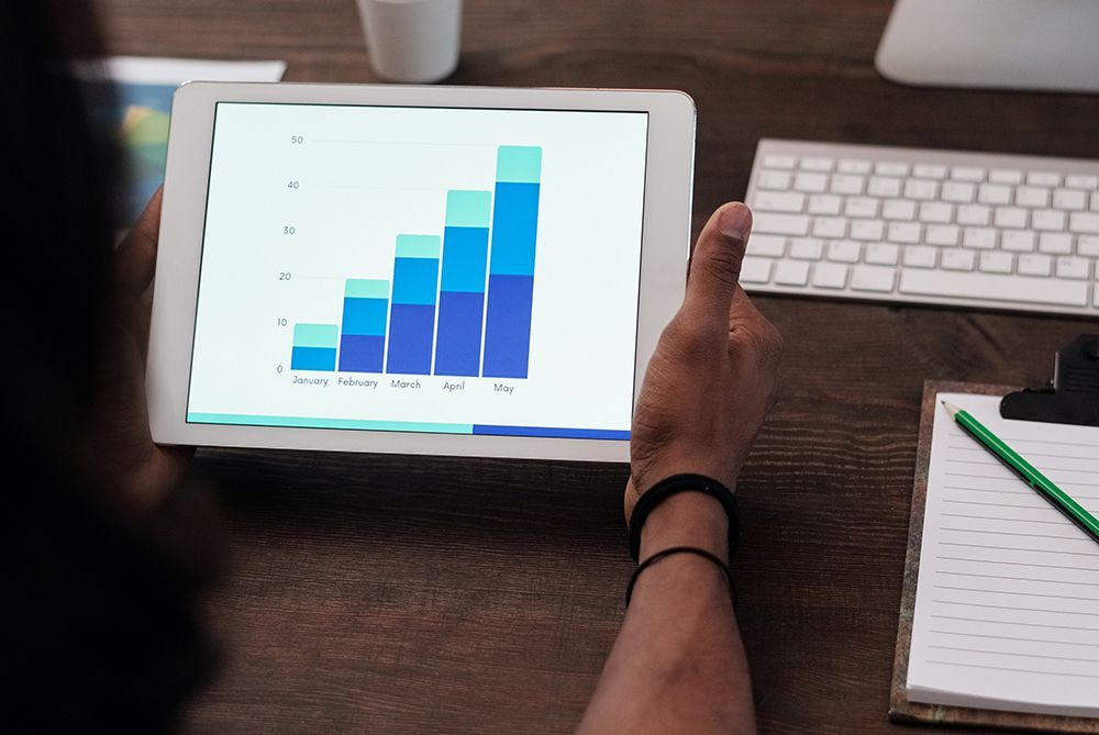 Person holding tablet showing bar graph on screen