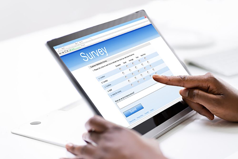 Person filling out a survey with their finger on a tablet