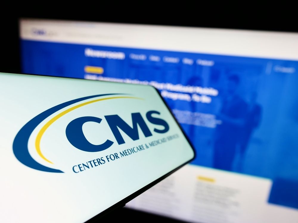 Phone with CMS logo displayed in front of CMS's website