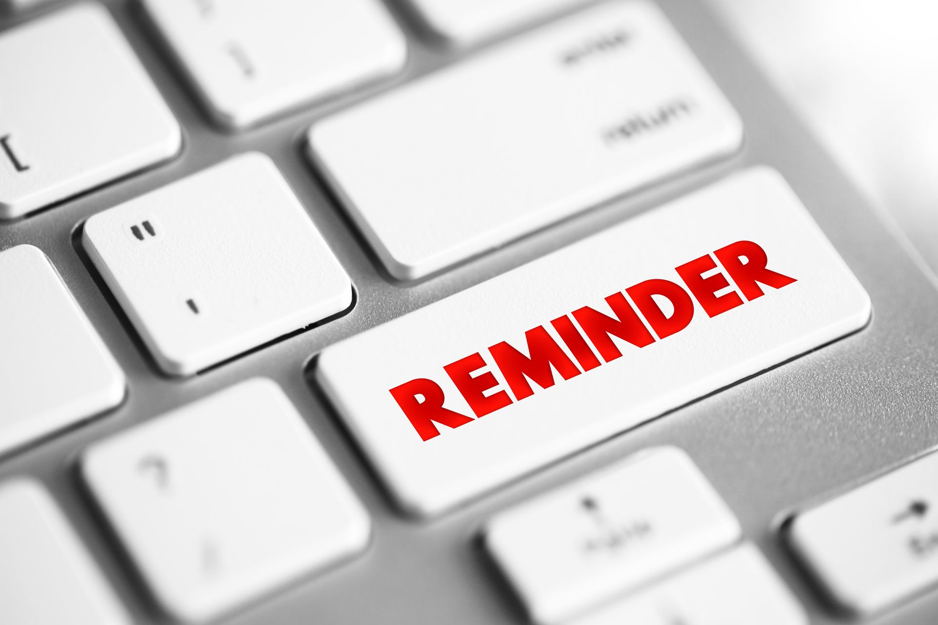Red “REMINDER” text on a white keyboard key