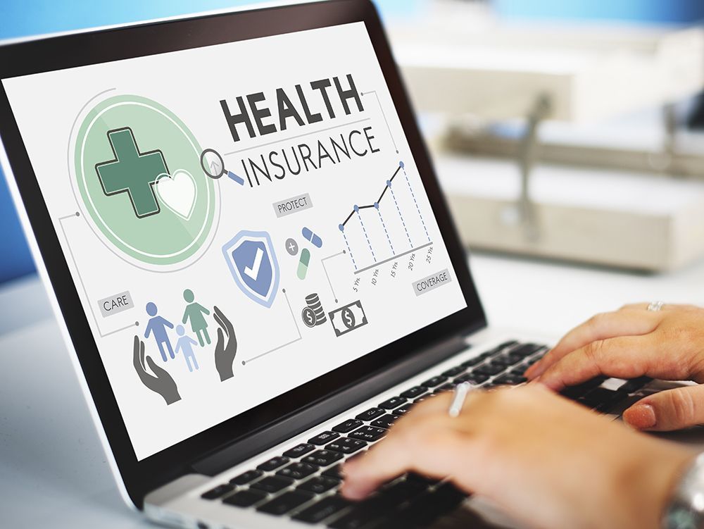 Person typing on laptop with health insurance markers on screen