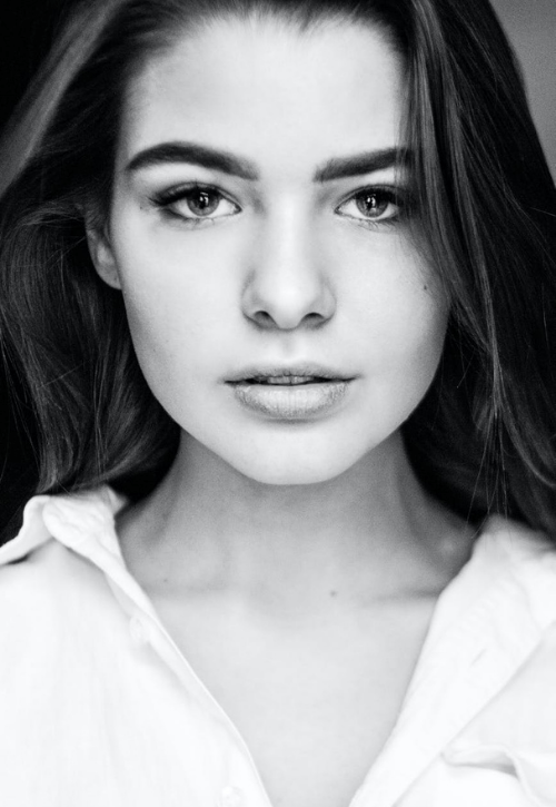 A black and white photo of a woman wearing a white shirt.