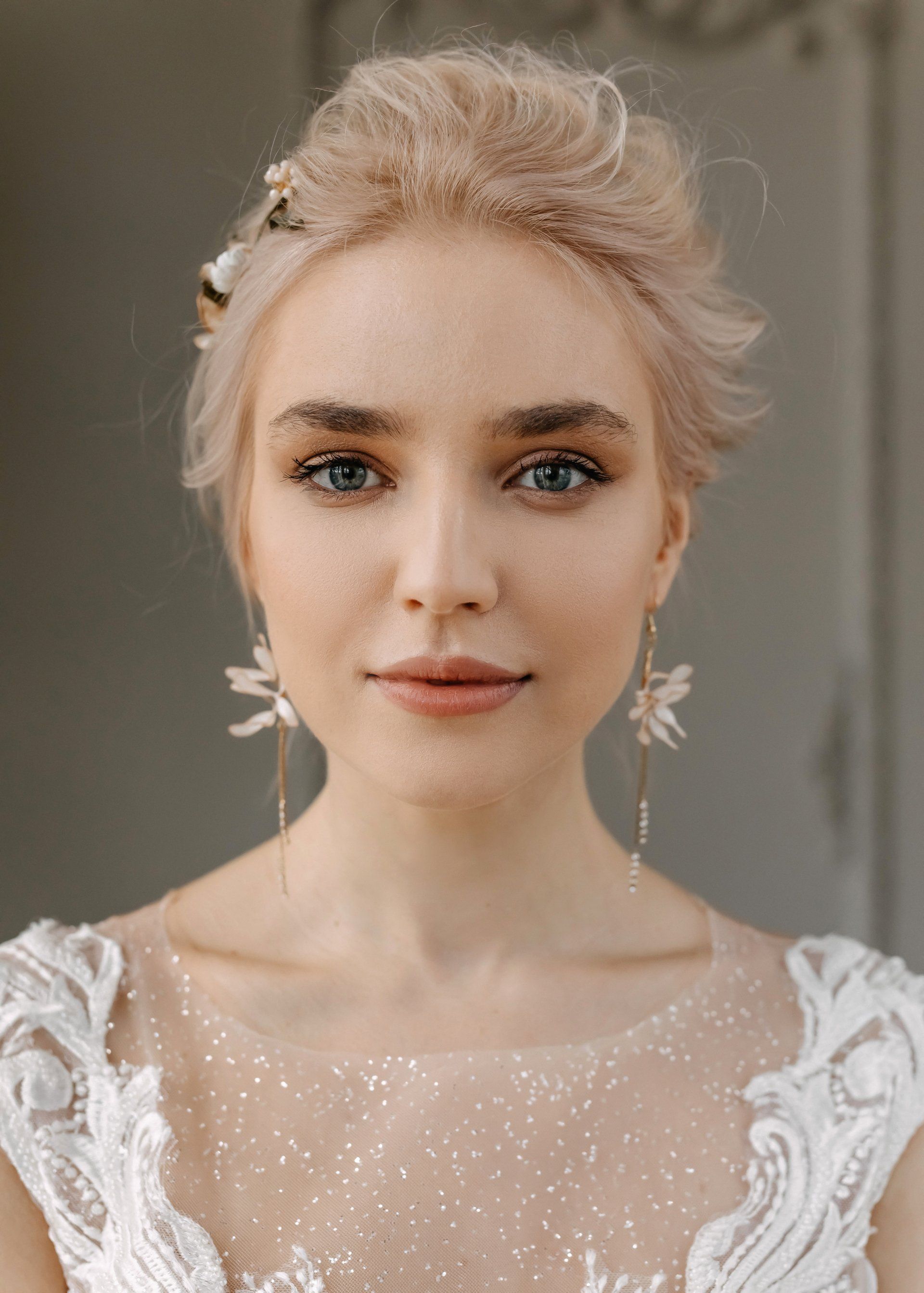 A close up of a woman wearing a wedding dress and earrings.