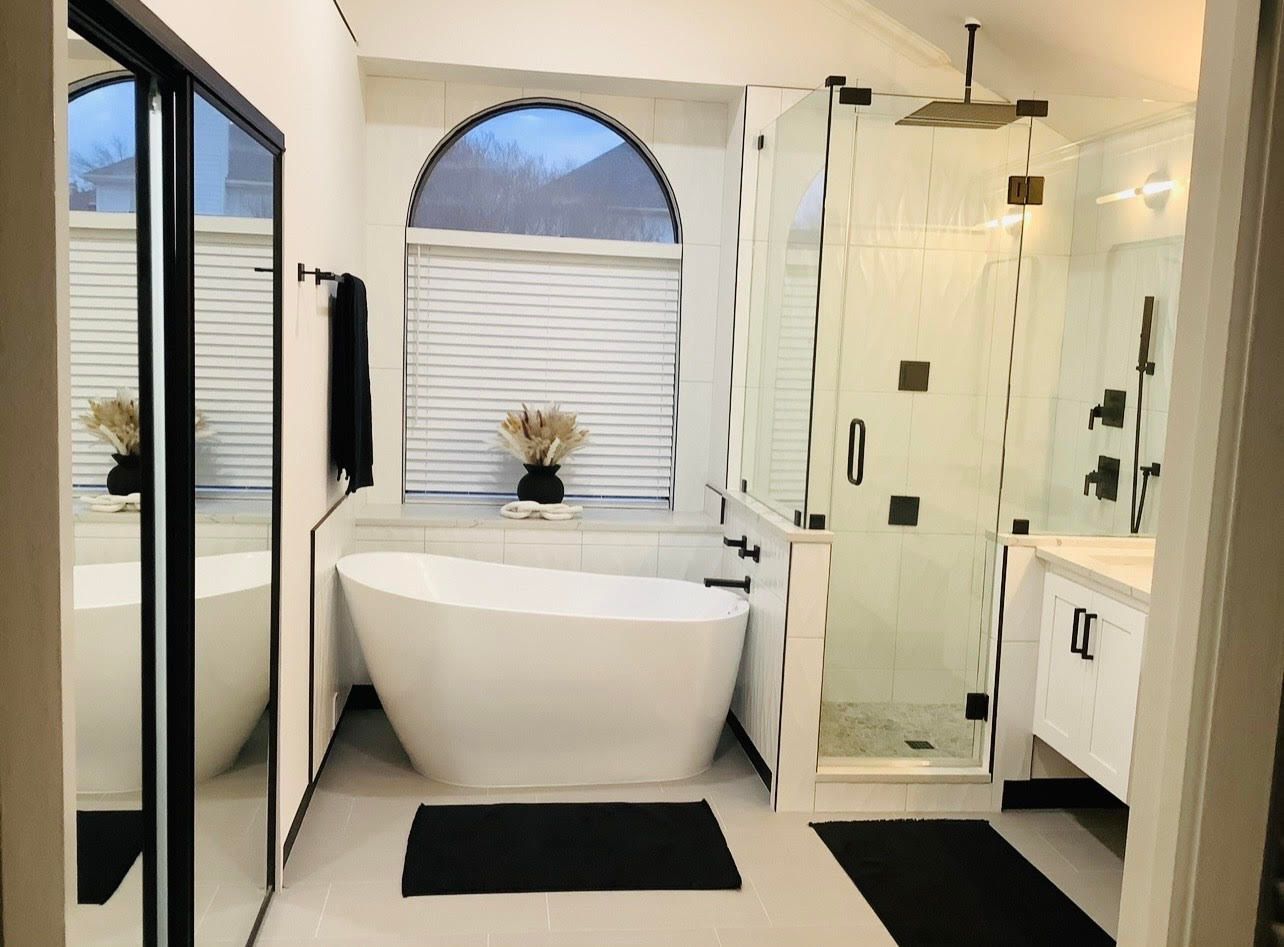 A bathroom with a tub , sink , and shower.