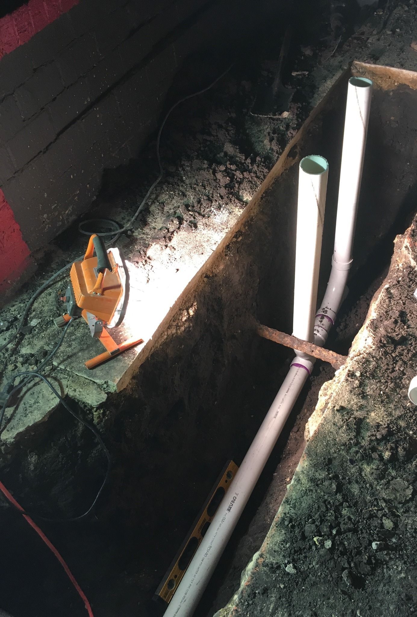A pipe is being installed in a hole in the ground.