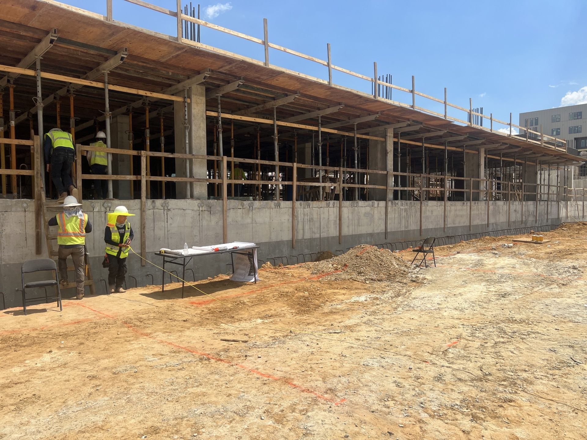 A group of construction workers are standing in front of a building under construction.