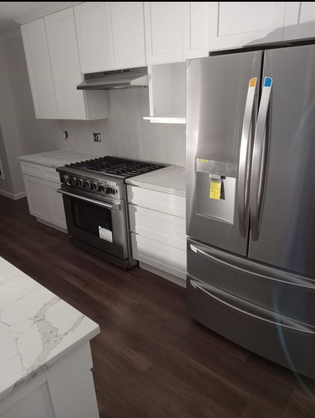A kitchen with stainless steel appliances and white cabinets