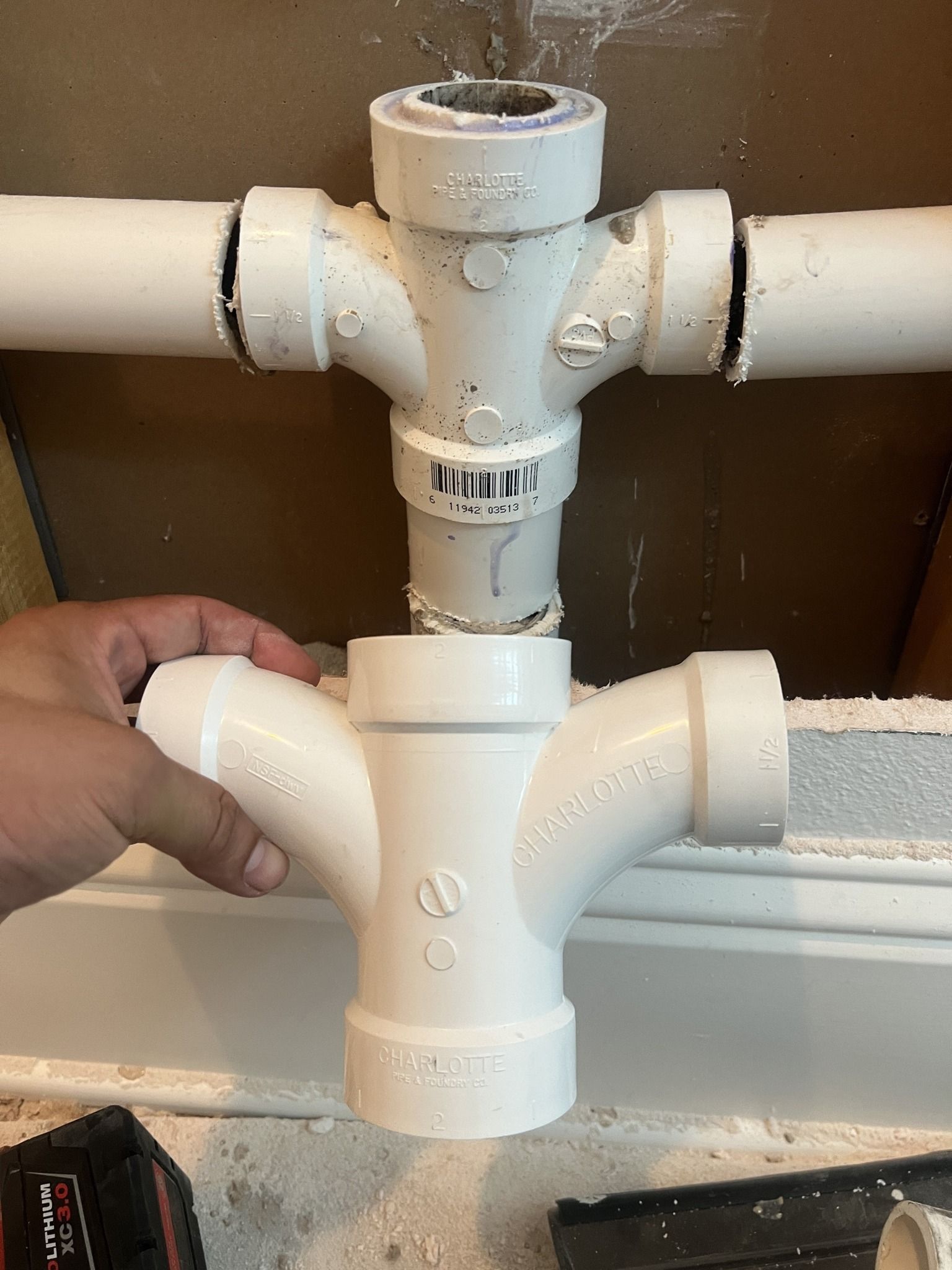 A person is holding a white pipe in their hand.