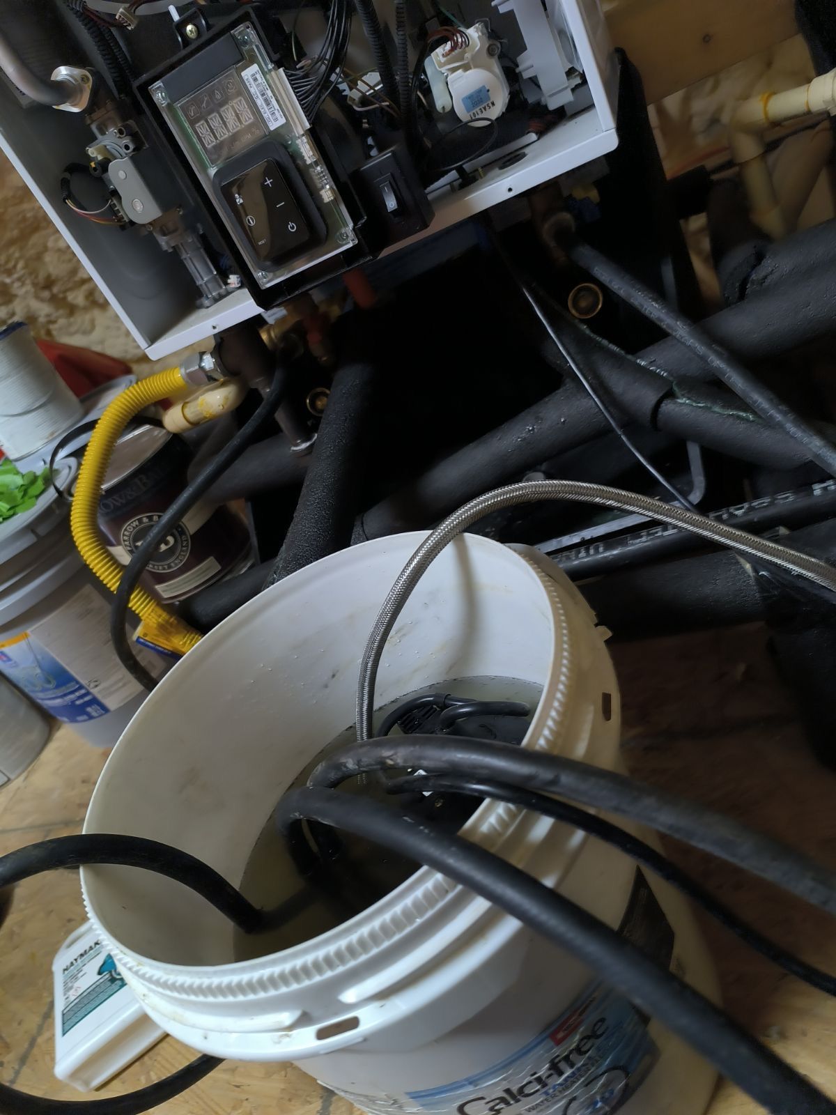 A bucket of water is sitting on a table next to a machine.