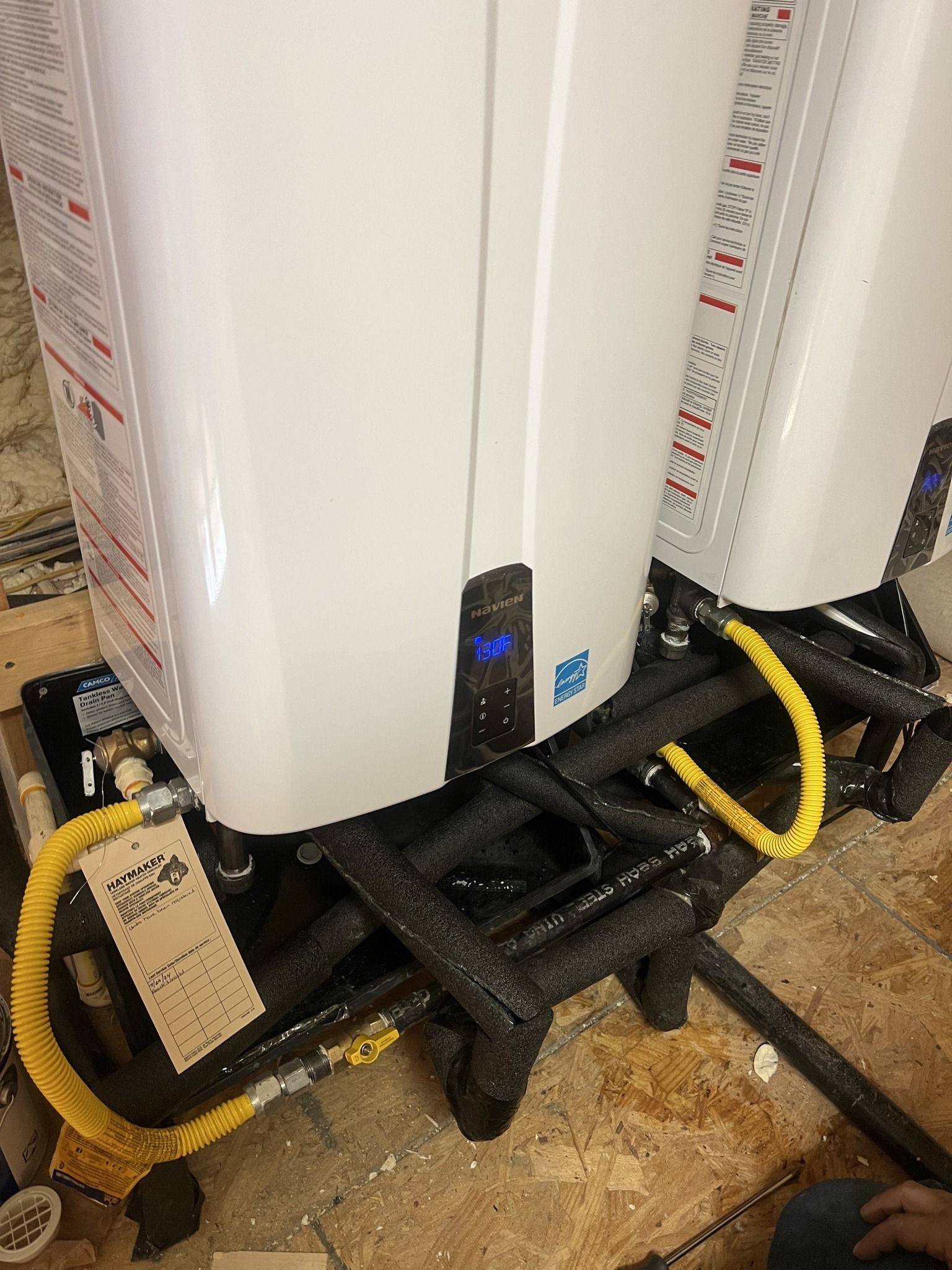 Two water heaters are sitting next to each other on the floor.