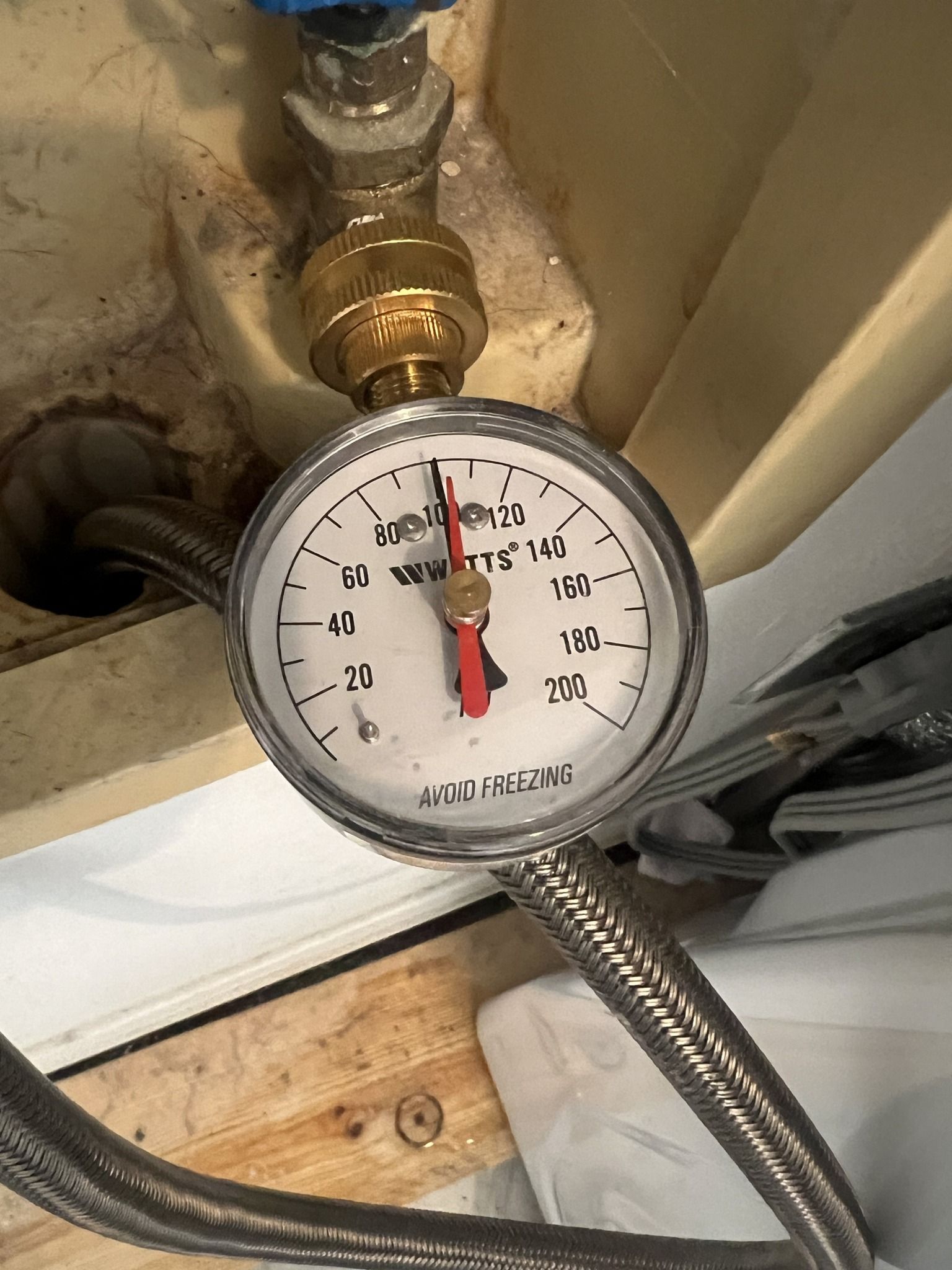 A close up of a pressure gauge attached to a pipe.