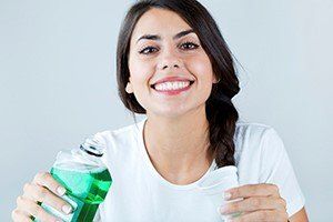 woman holding mouthwash - mouthwash can be both bad and good blog