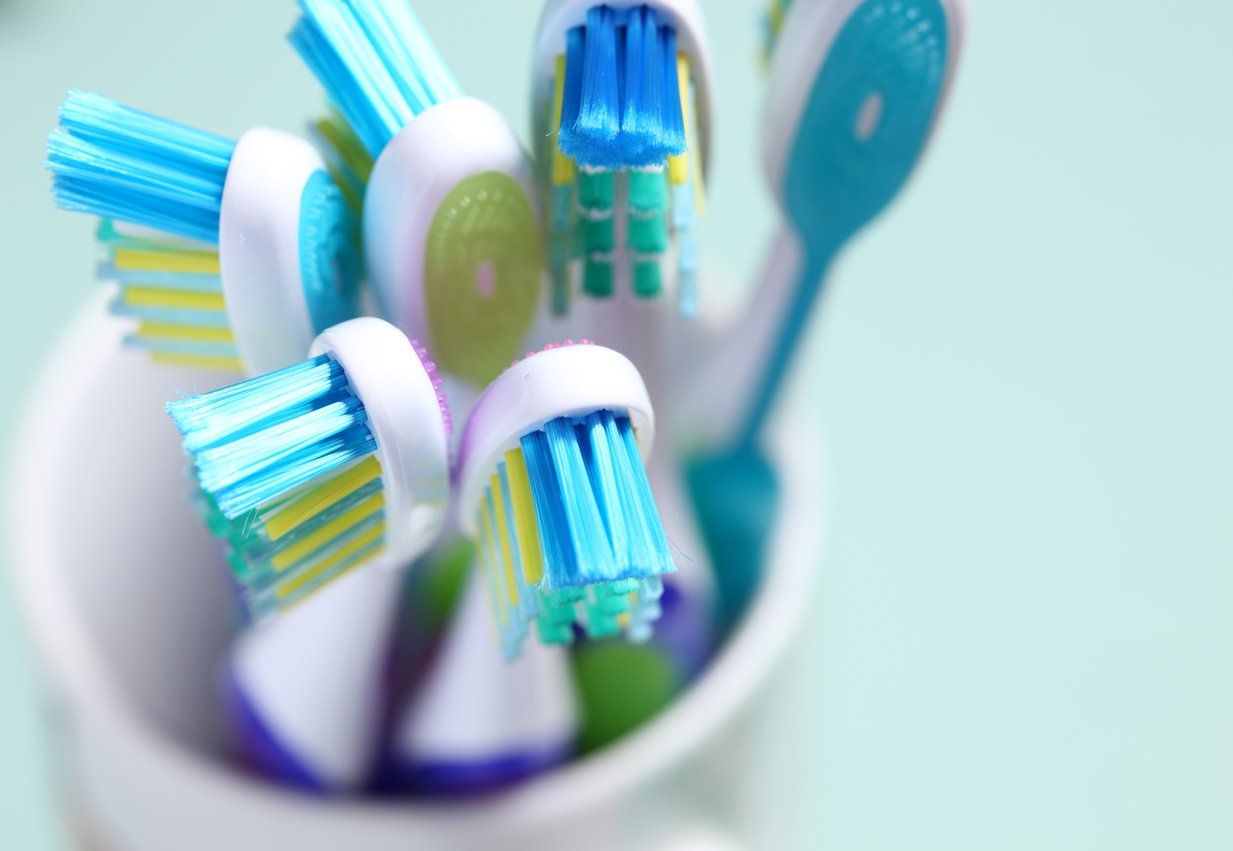 toothbrushes in cup on bathroom counter