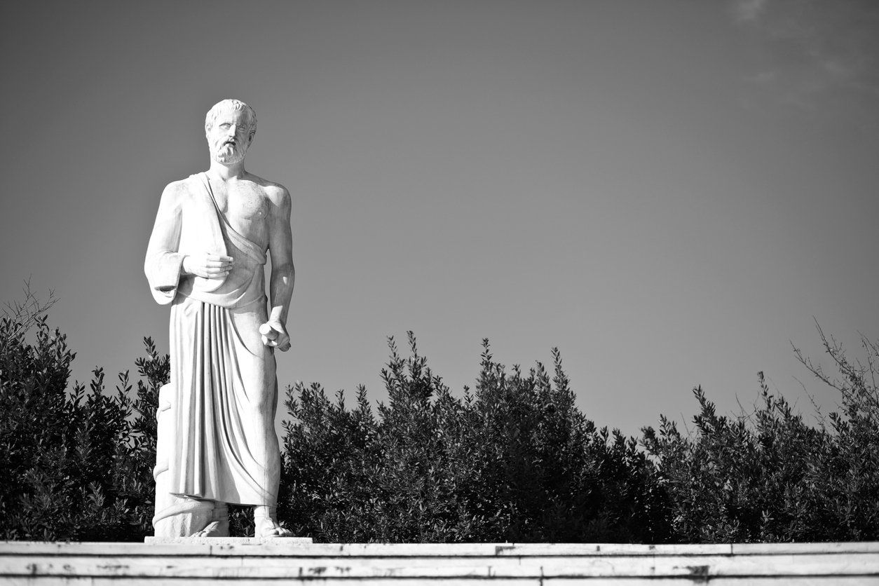 gray-scale-photo-of-hippocrates-statue-in-front-of-trees