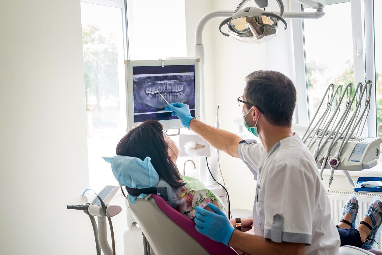 dentist showing woman teeth xrays