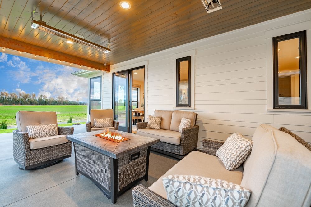 Outdoor patio with wicker furniture, a fire pit, and a view of a field.