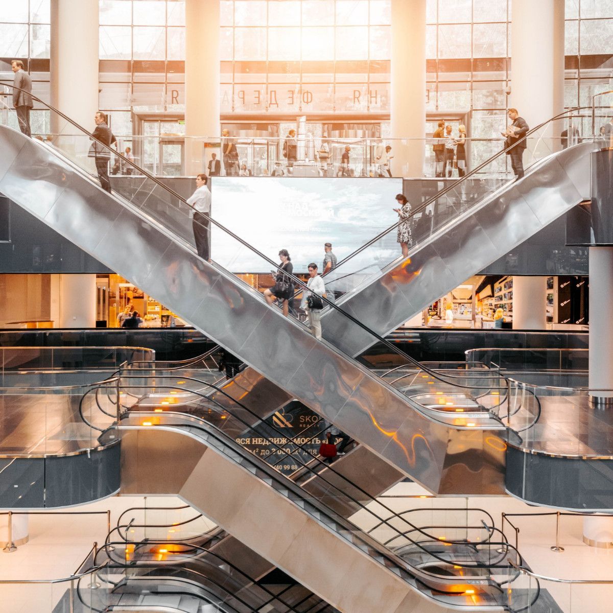 a group of people are riding escalators in a shopping mall .