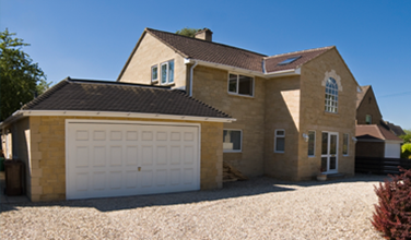 a large house with a garage and driveway in front of it .