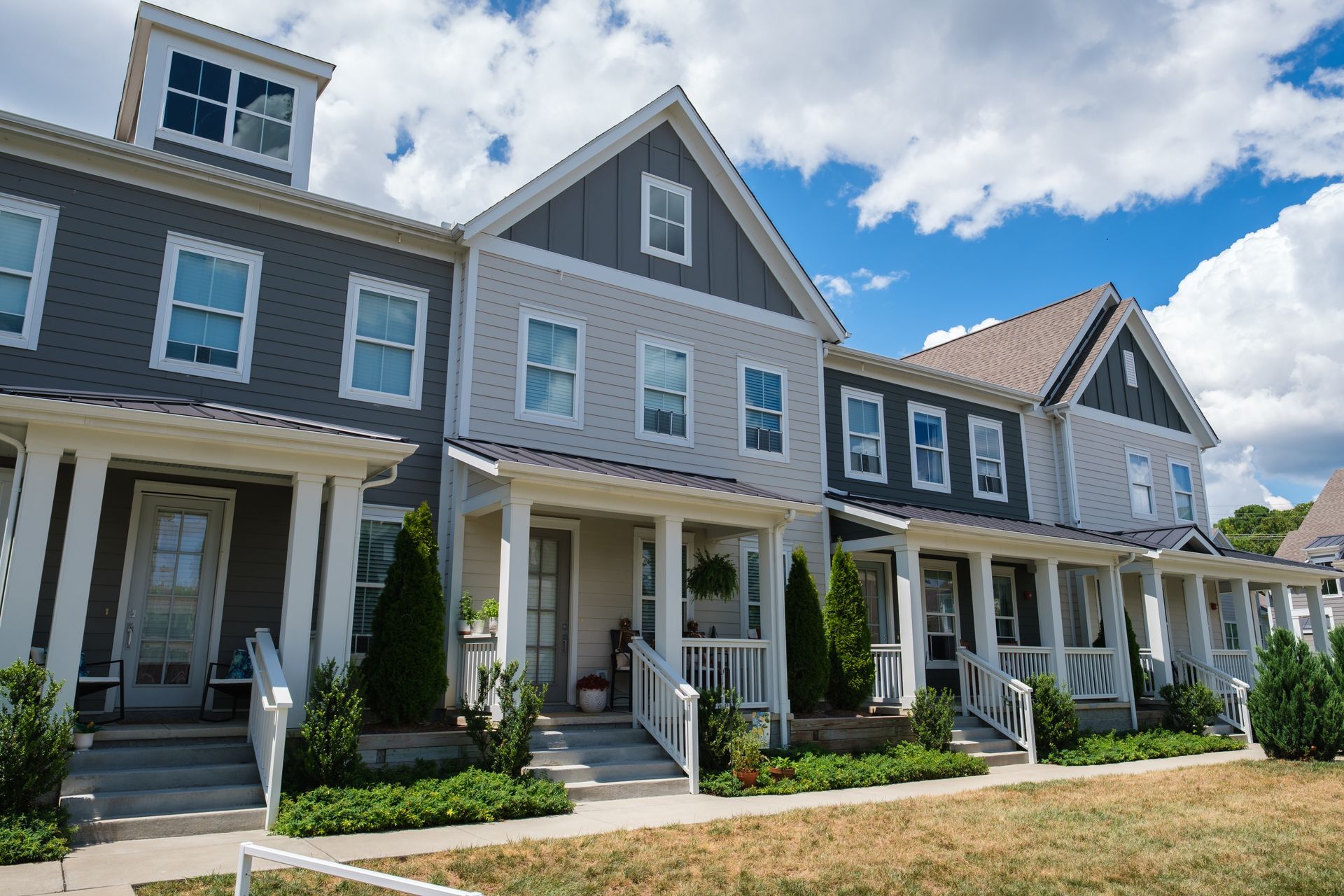 Newly built townhomes with front porches and landscaped walkways.