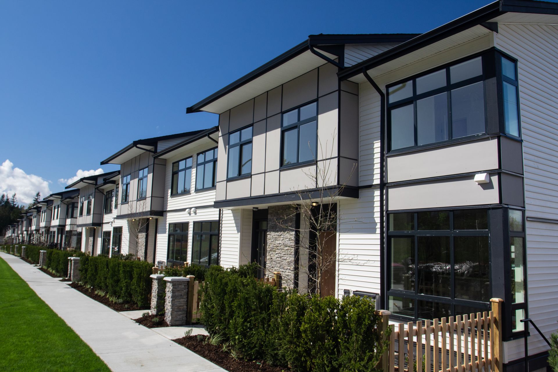 Row of residential townhouses and a blue sky background on a sunny day.