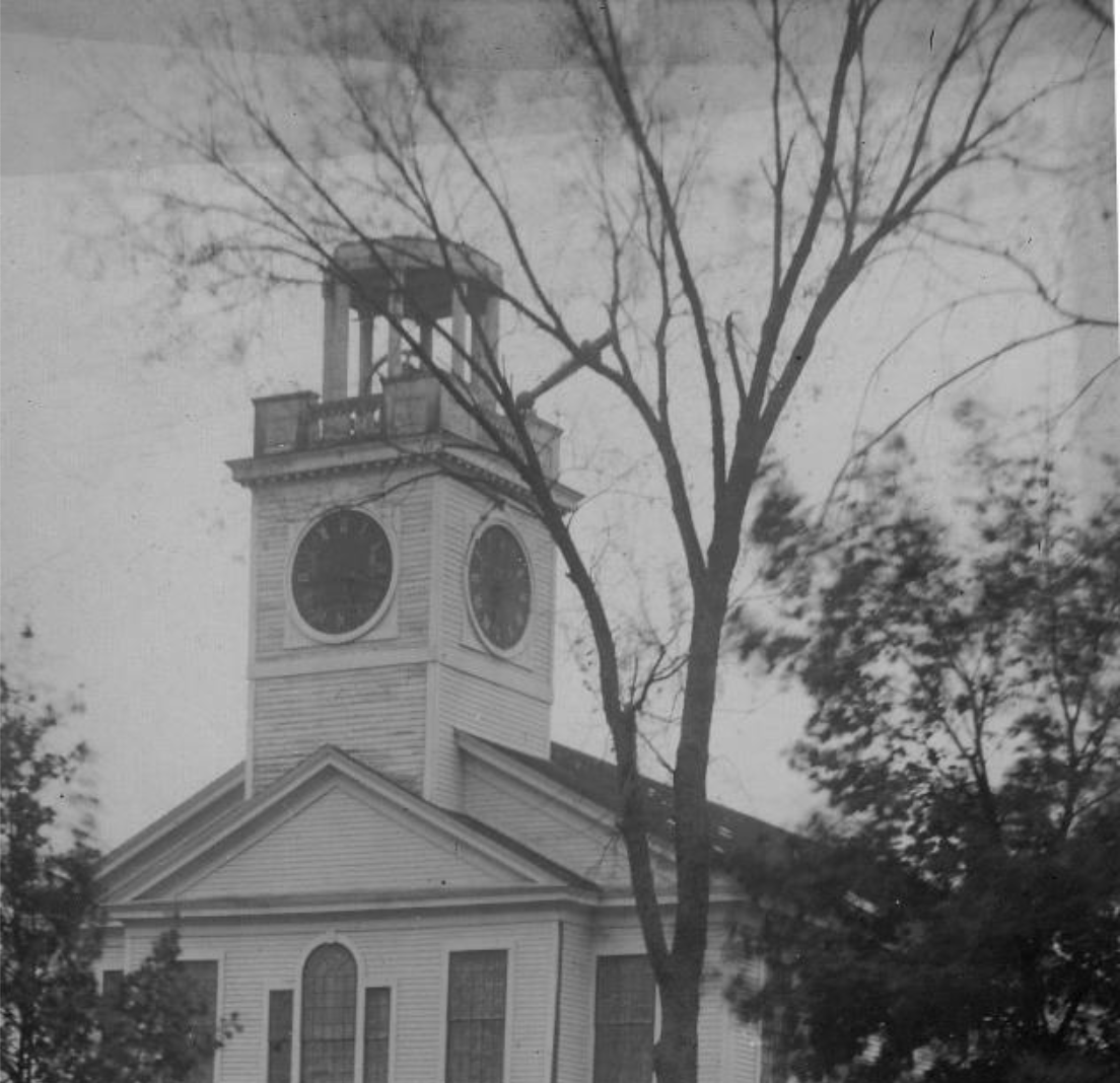 A black and white photo of a church with a clock tower