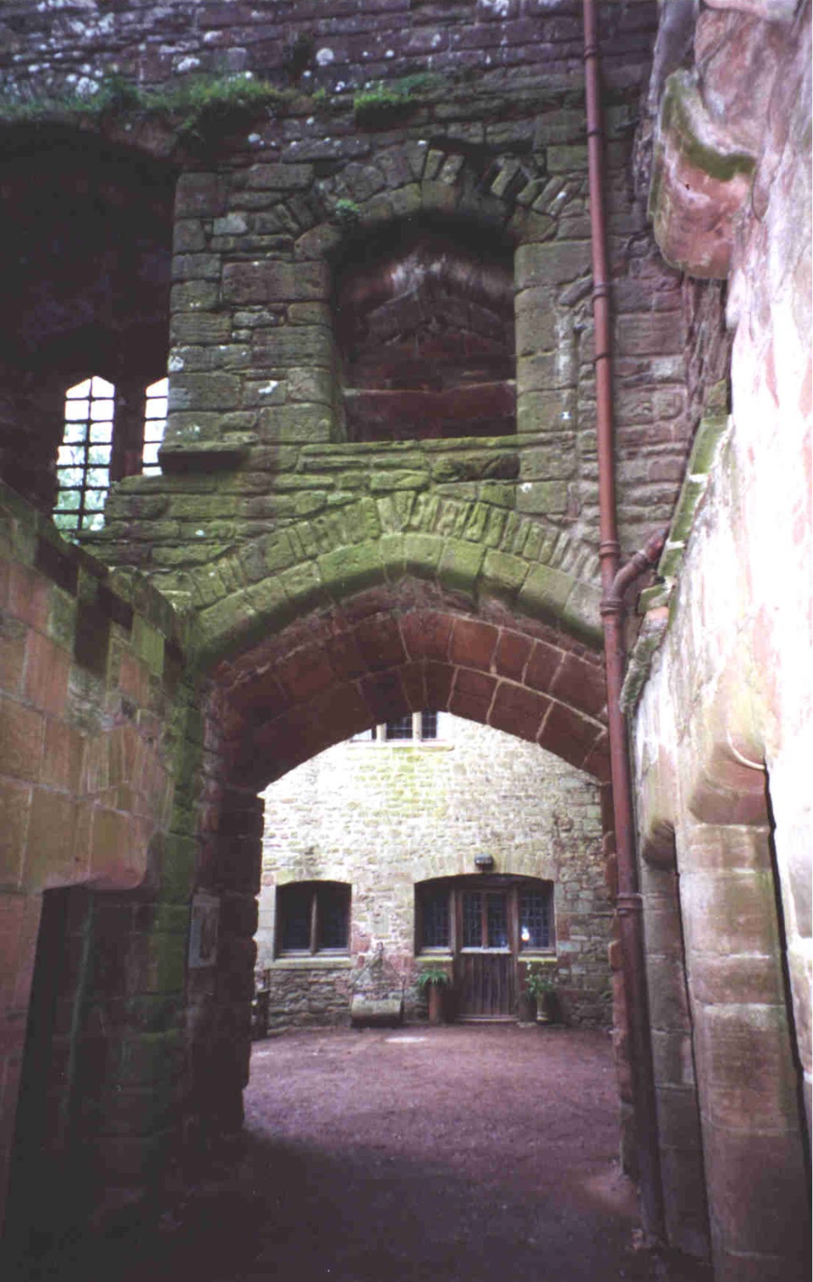 A stone archway leading to a building with windows