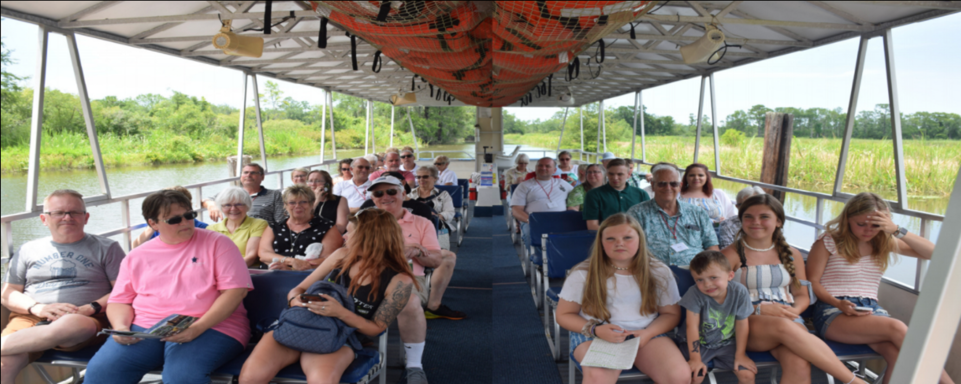 A large group of people are sitting on a boat.