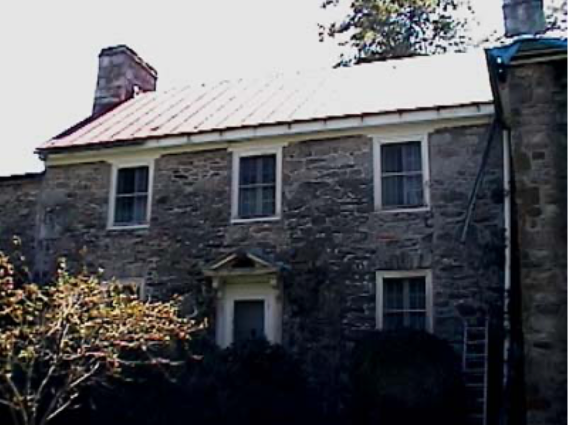 A large stone house with a metal roof
