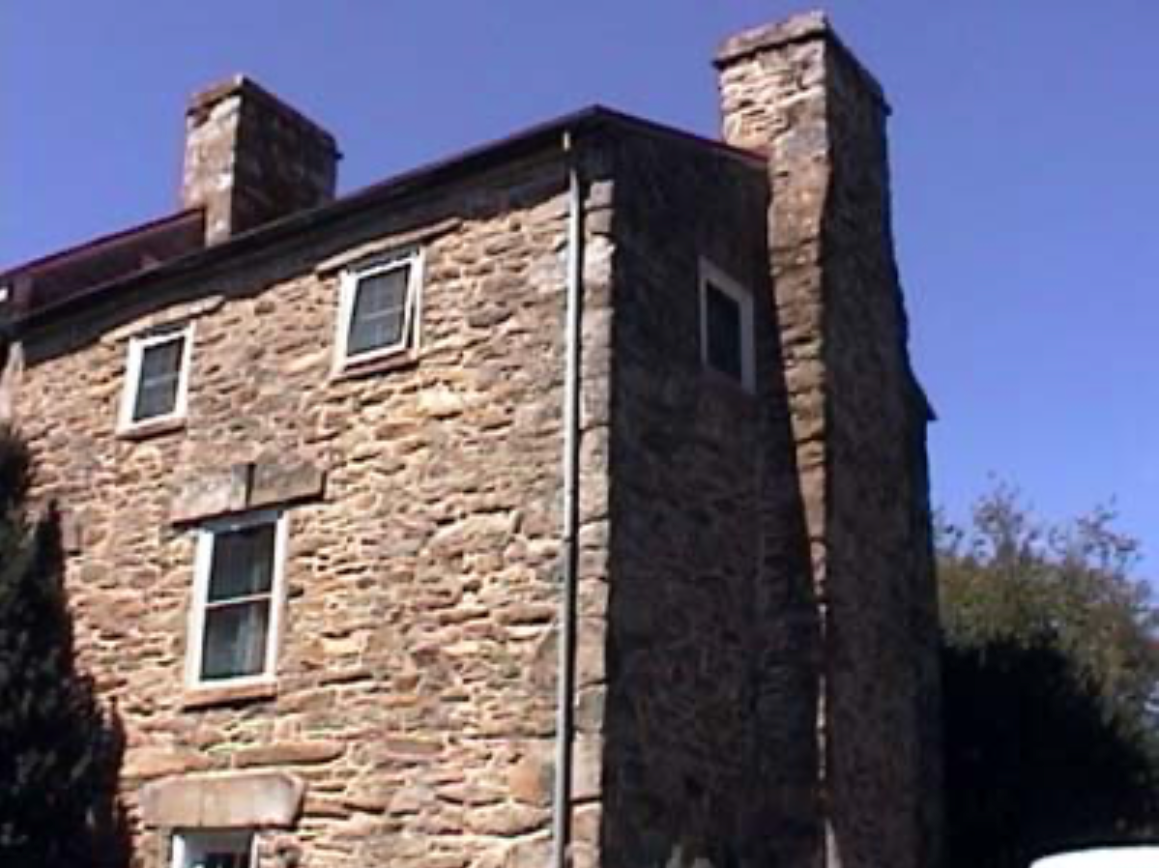 A large stone building with a chimney on the side