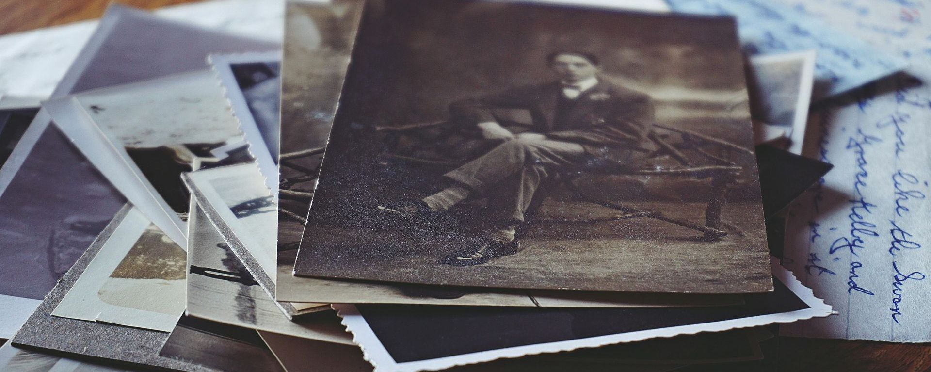 A stack of old photos of a man sitting on a bench.