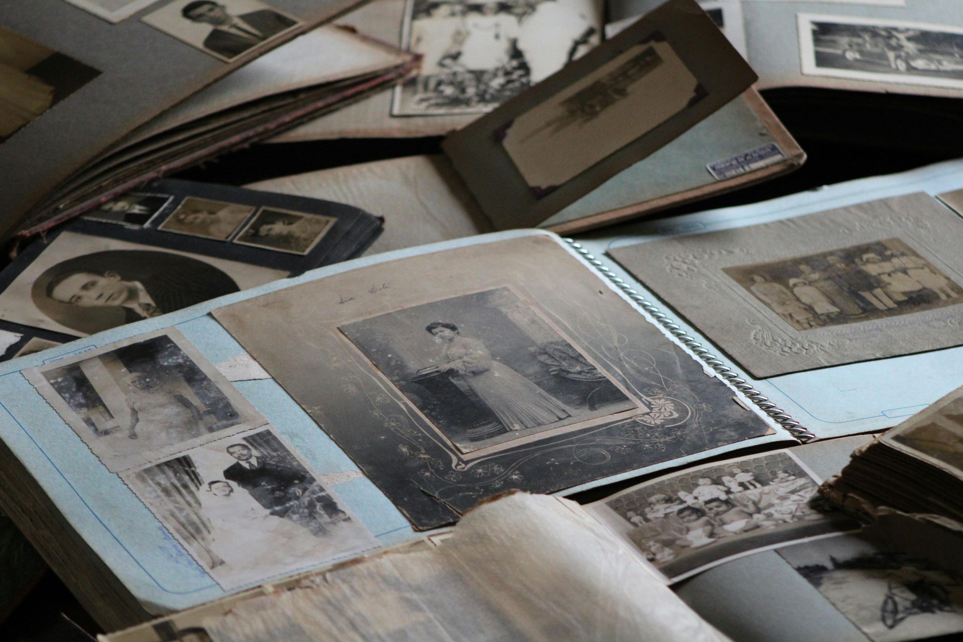 A pile of old photographs including one of a woman