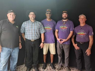 A group of men standing next to each other wearing purple shirts