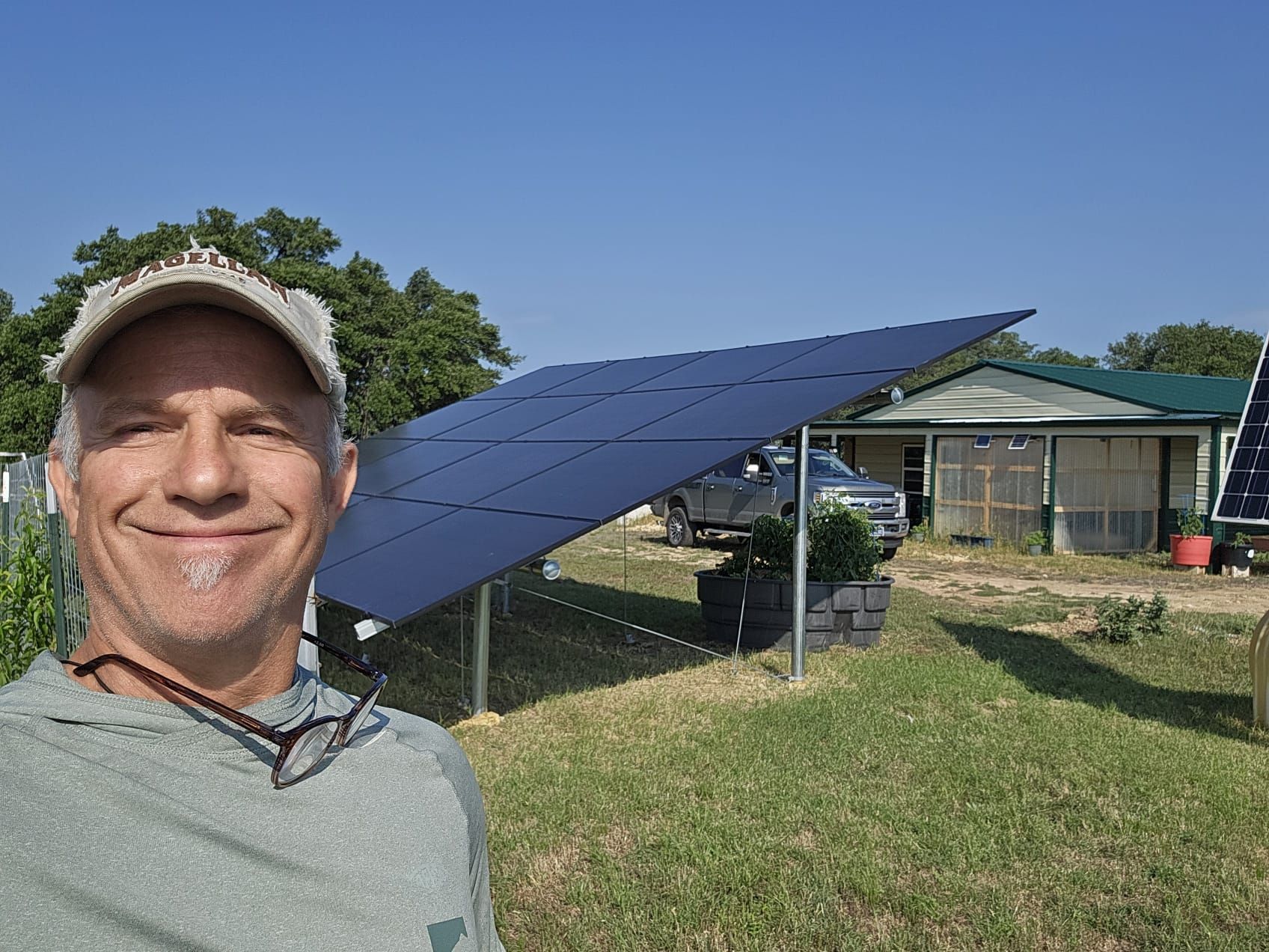 A man is standing in front of a house with solar panels.