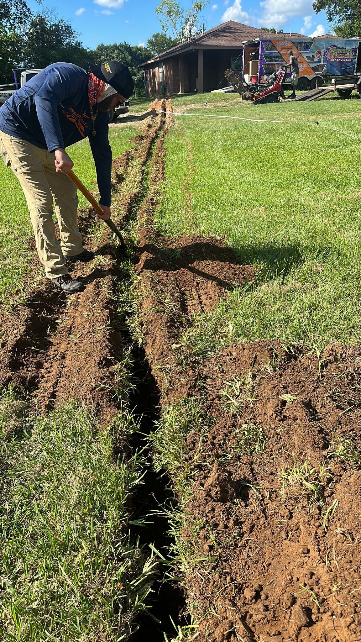 A man is digging a hole in the ground with a shovel.