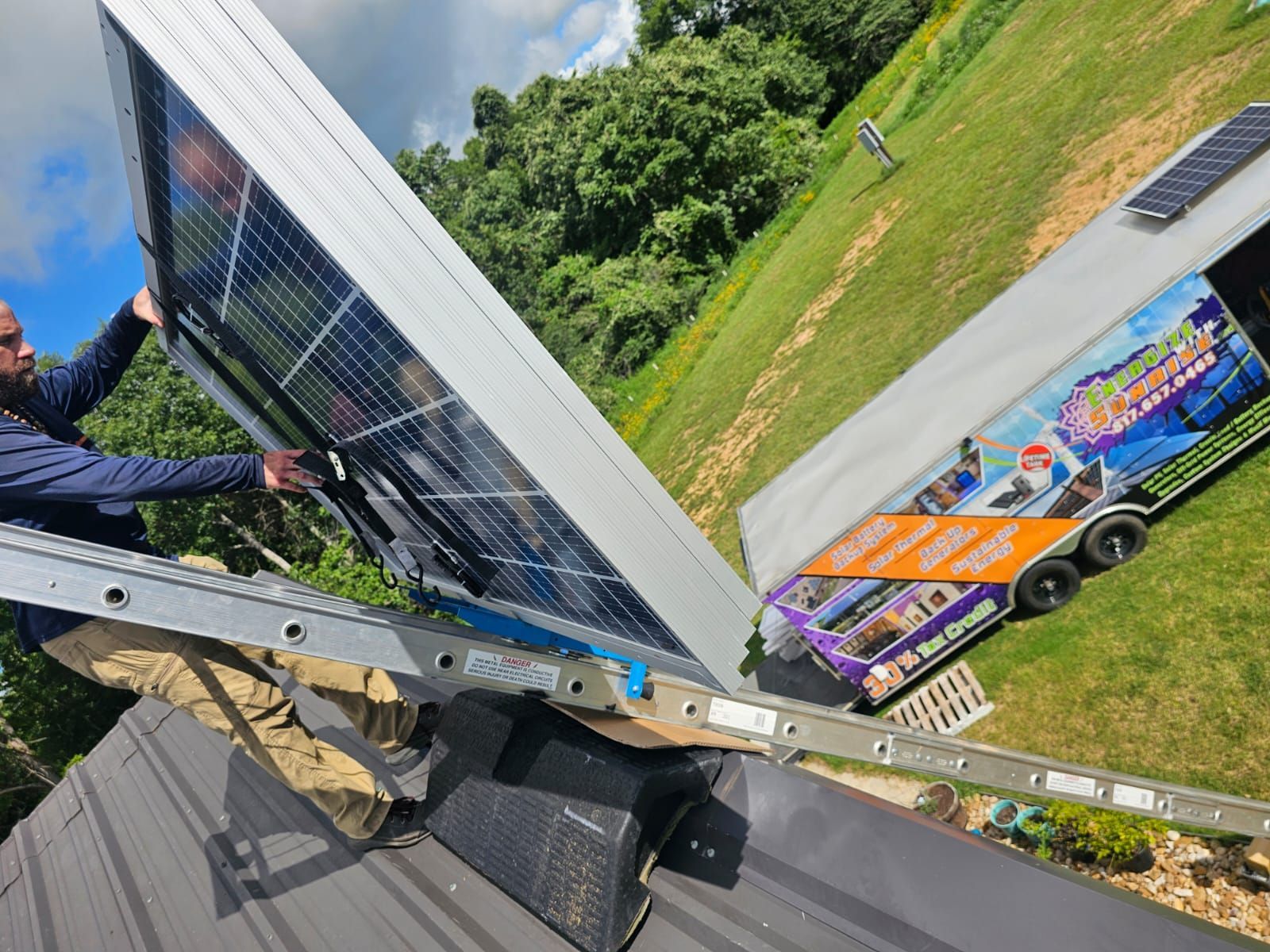 A man is installing a solar panel on the roof of a house.