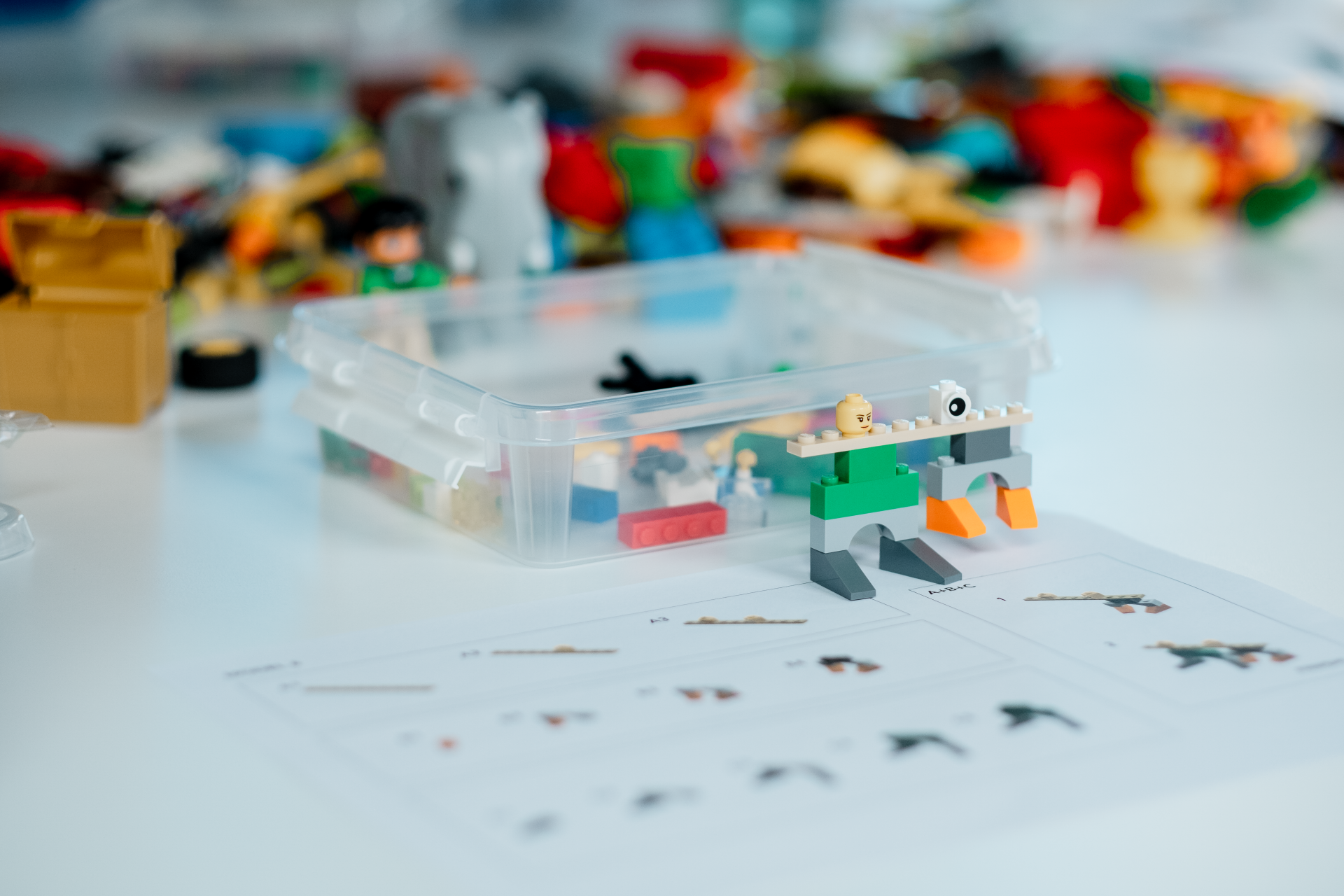 A box filled with lego blocks is sitting on a table.