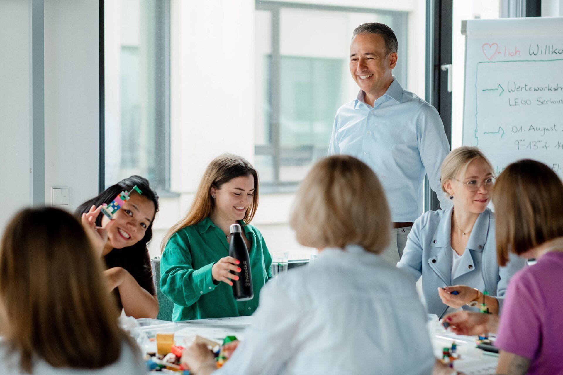 A group of people are sitting around a table having a meeting.