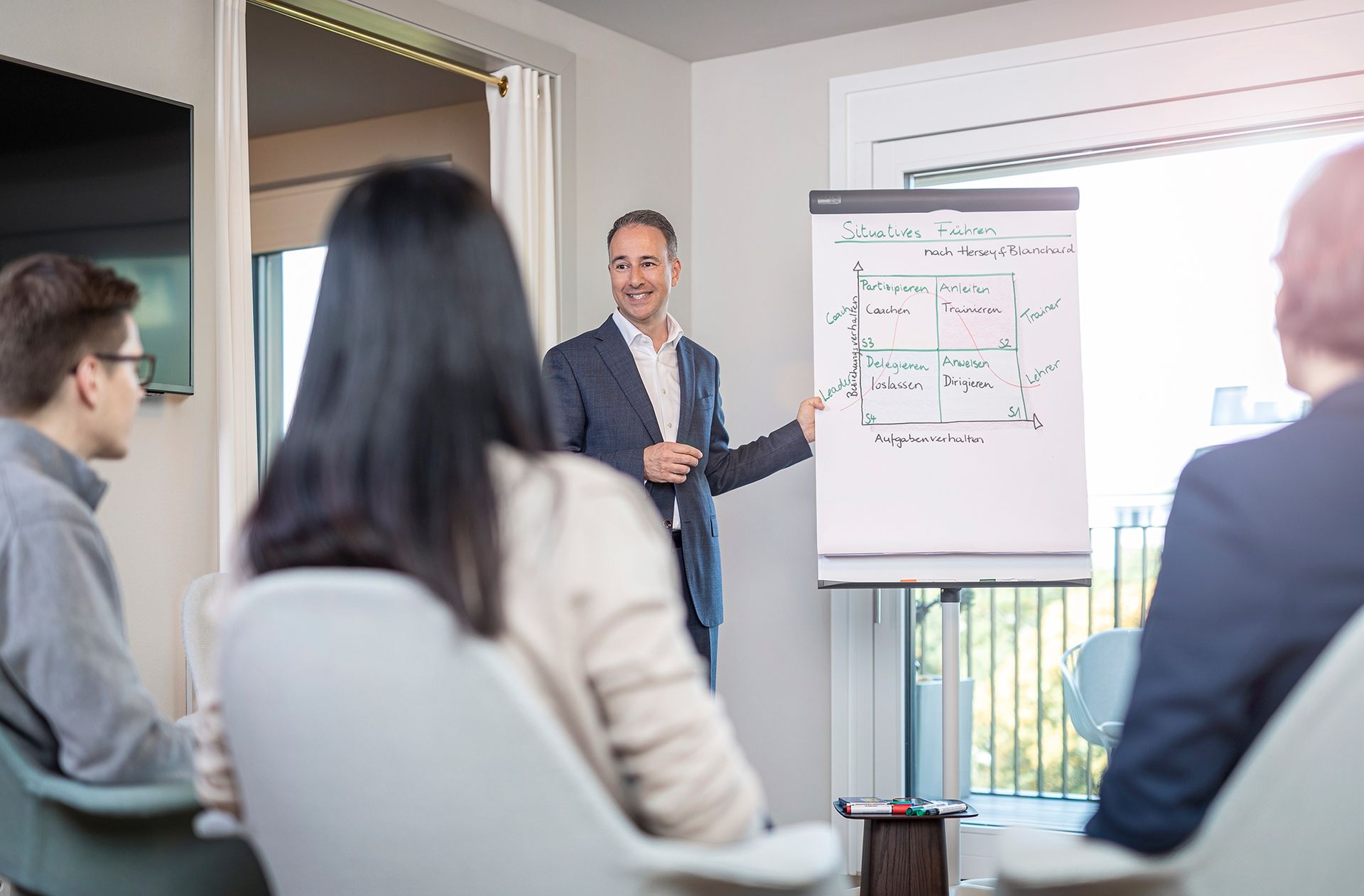 A man is giving a presentation to a group of people in a conference room.