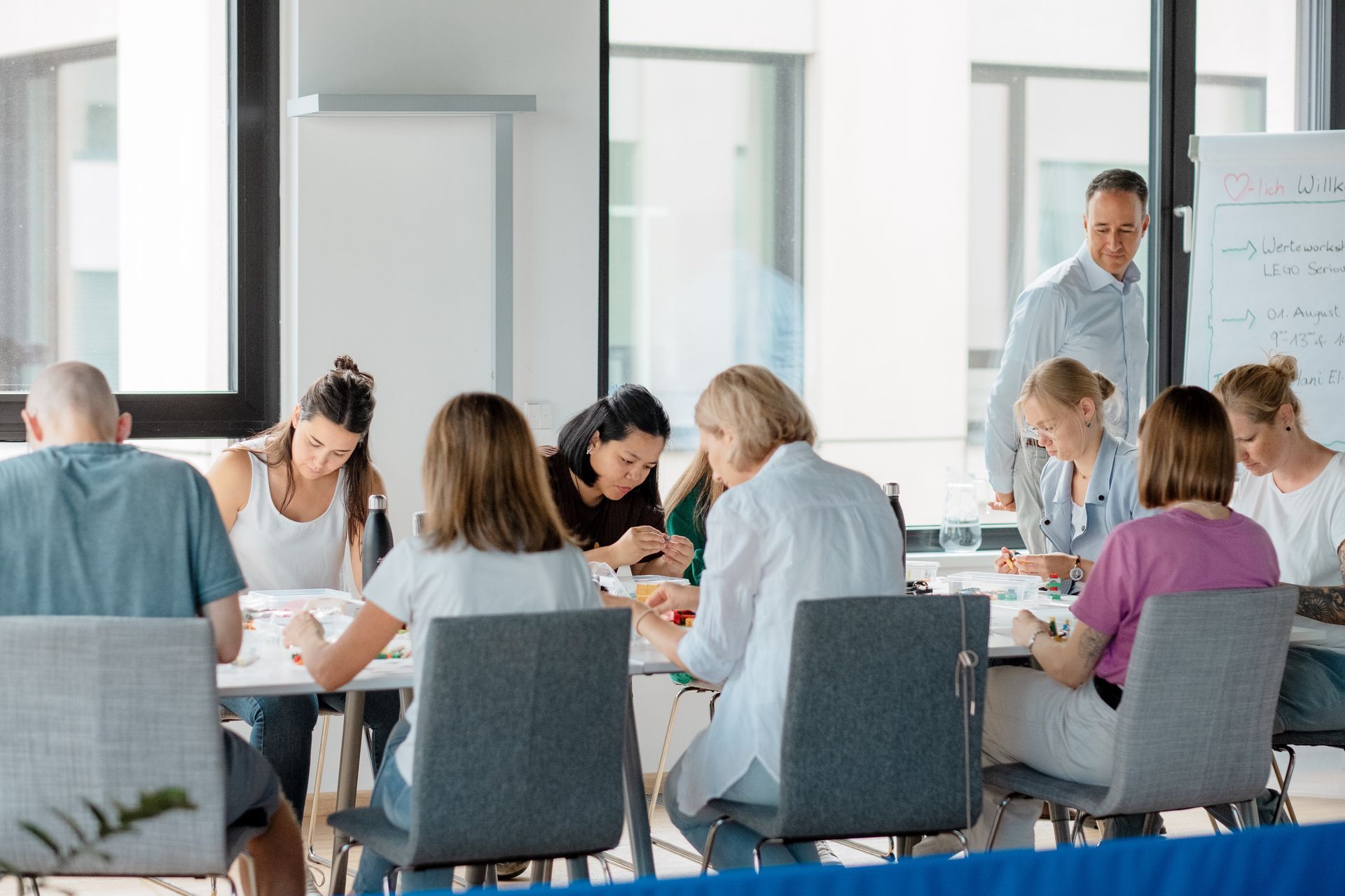 Eine Gruppe von Leuten sitzt in einem Konferenzraum um einen Tisch herum.