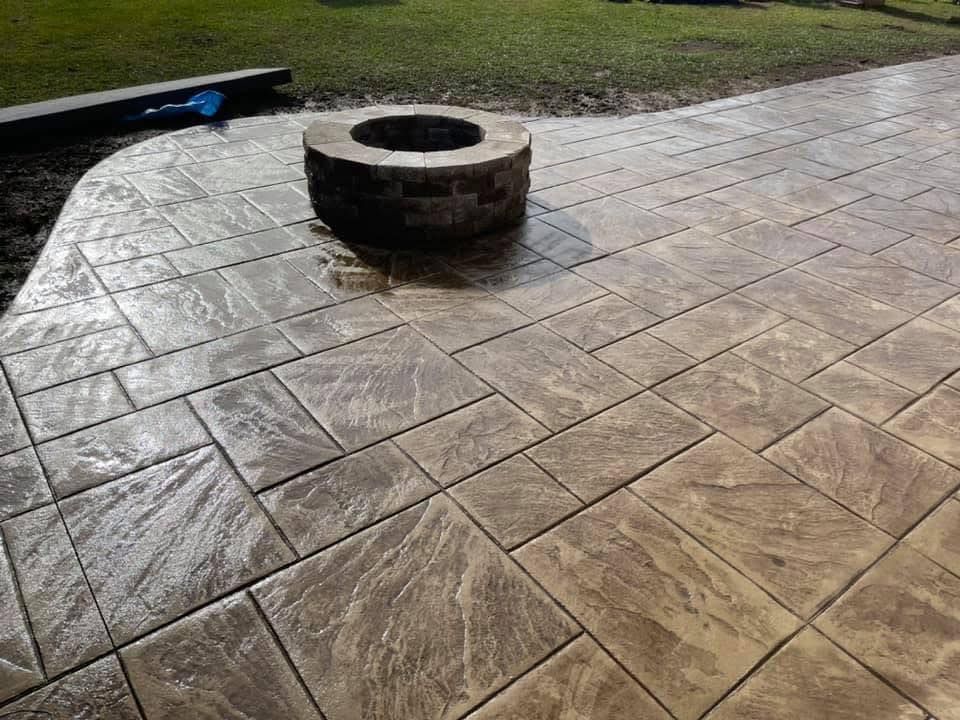 Stamped concrete patio with a brick fire pit.
