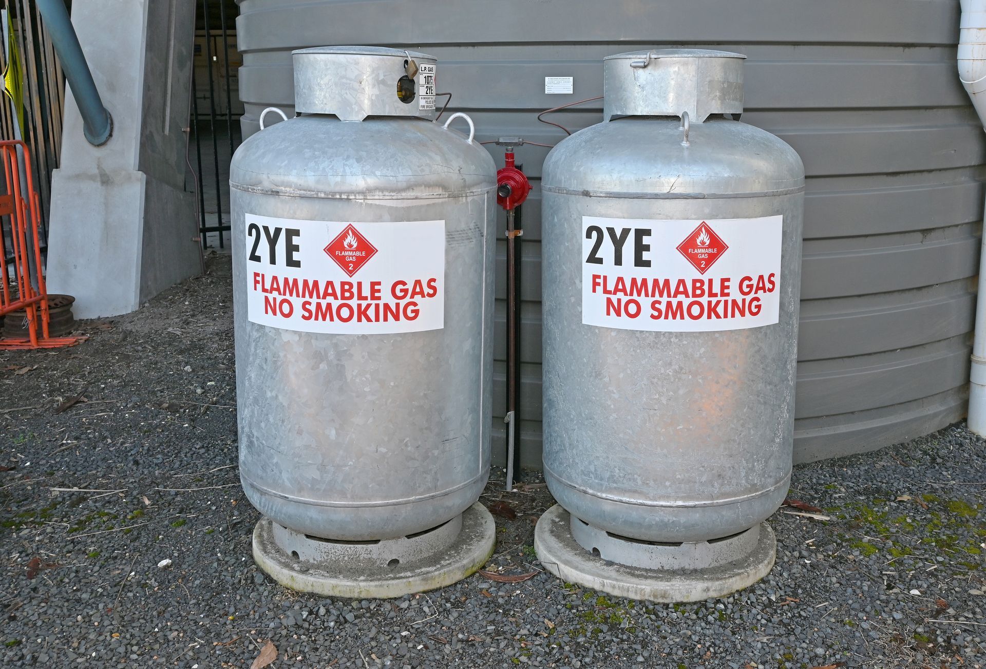 Two flammable gas tanks are sitting next to each other