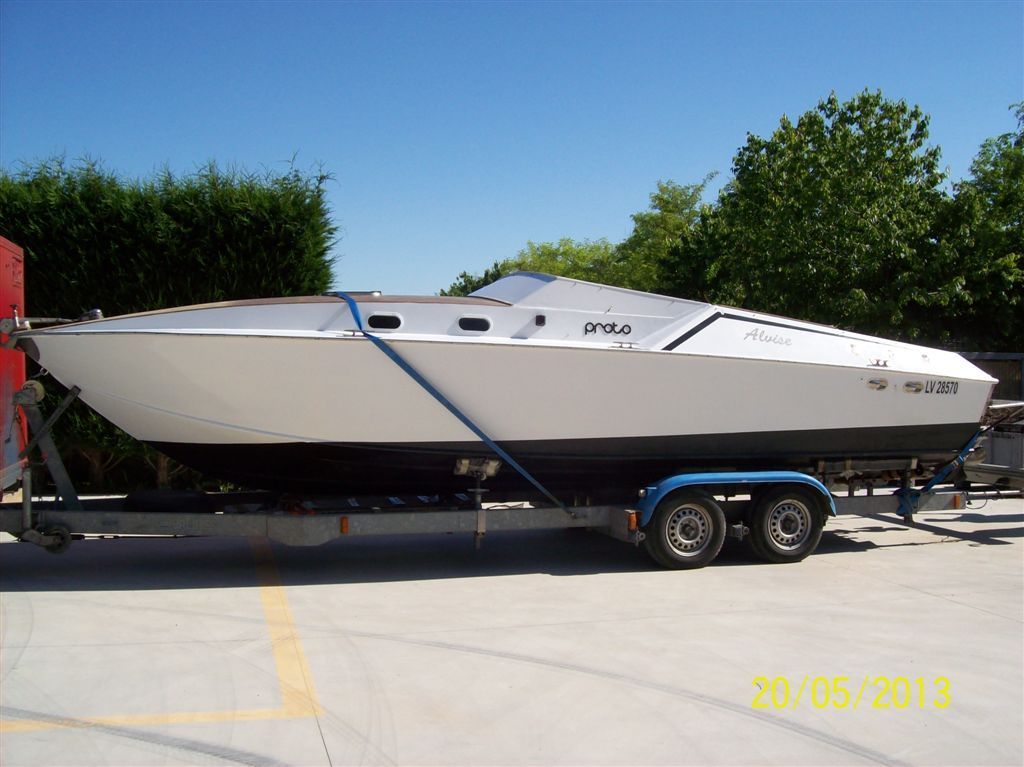 Barca a vela bianca su un rimorchio, con cielo azzurro sullo sfondo.