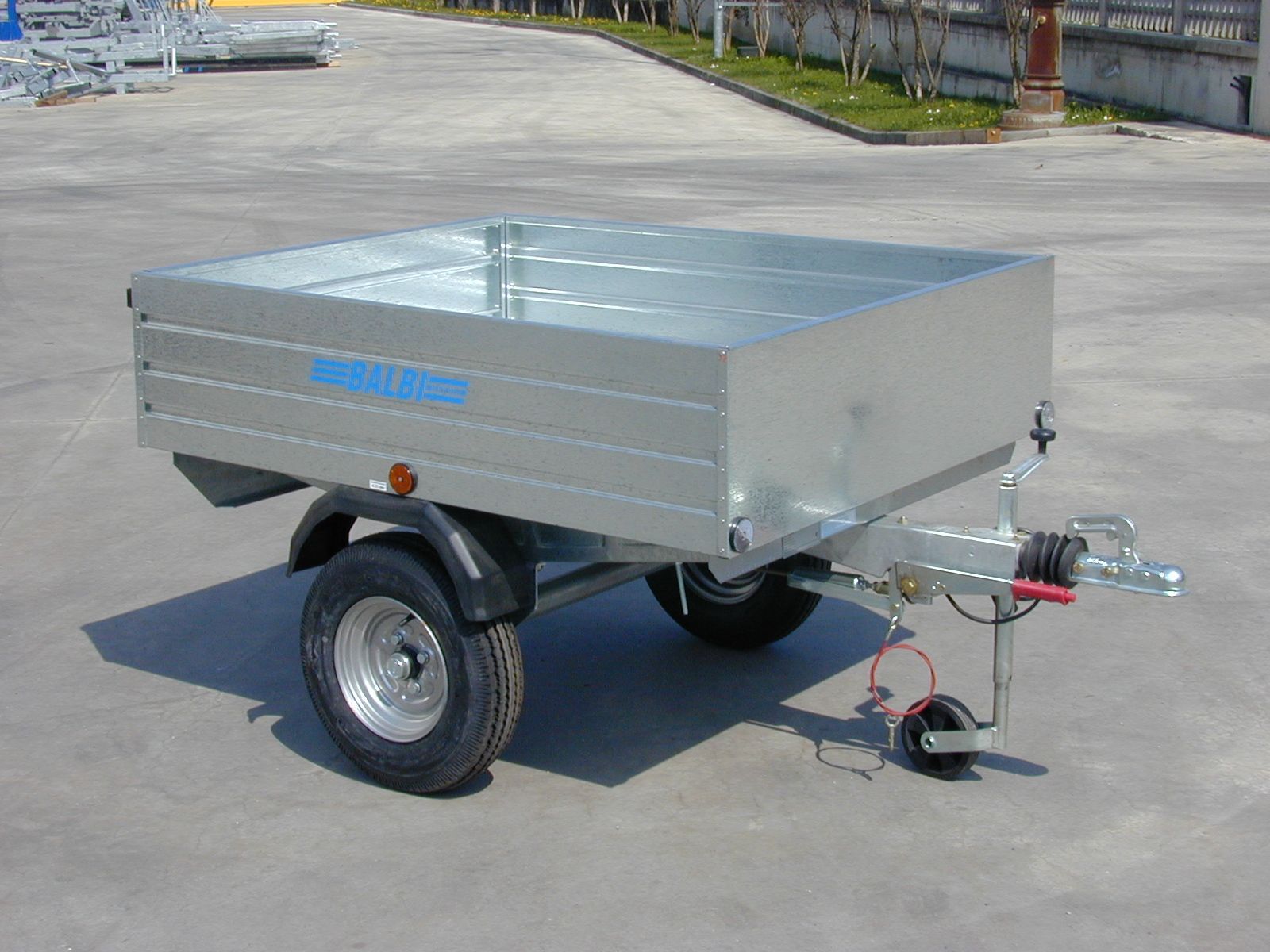 Rimorchio utilitario color argento su una superficie pavimentata, all'aperto.