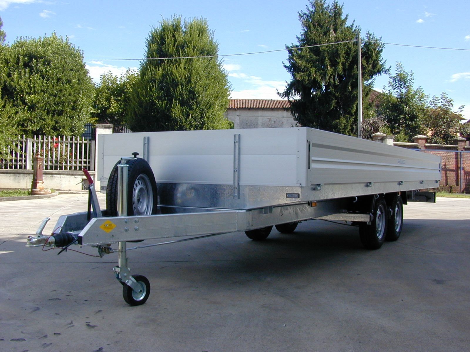 Un rimorchio con ruota di scorta, parcheggiato all'aperto alla luce del giorno.