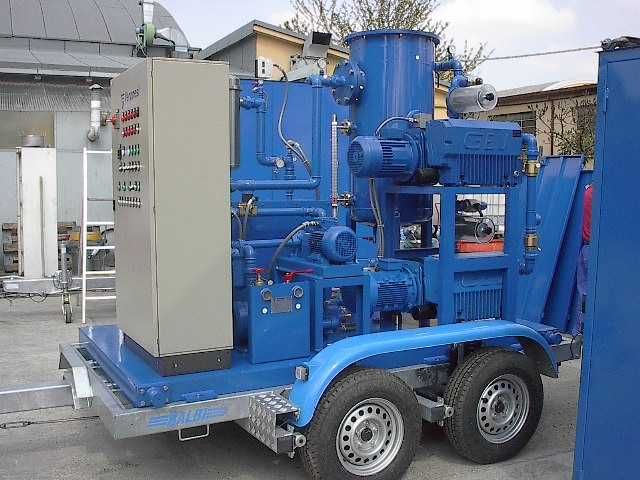 Macchina industriale blu su rimorchio con pannello di controllo.